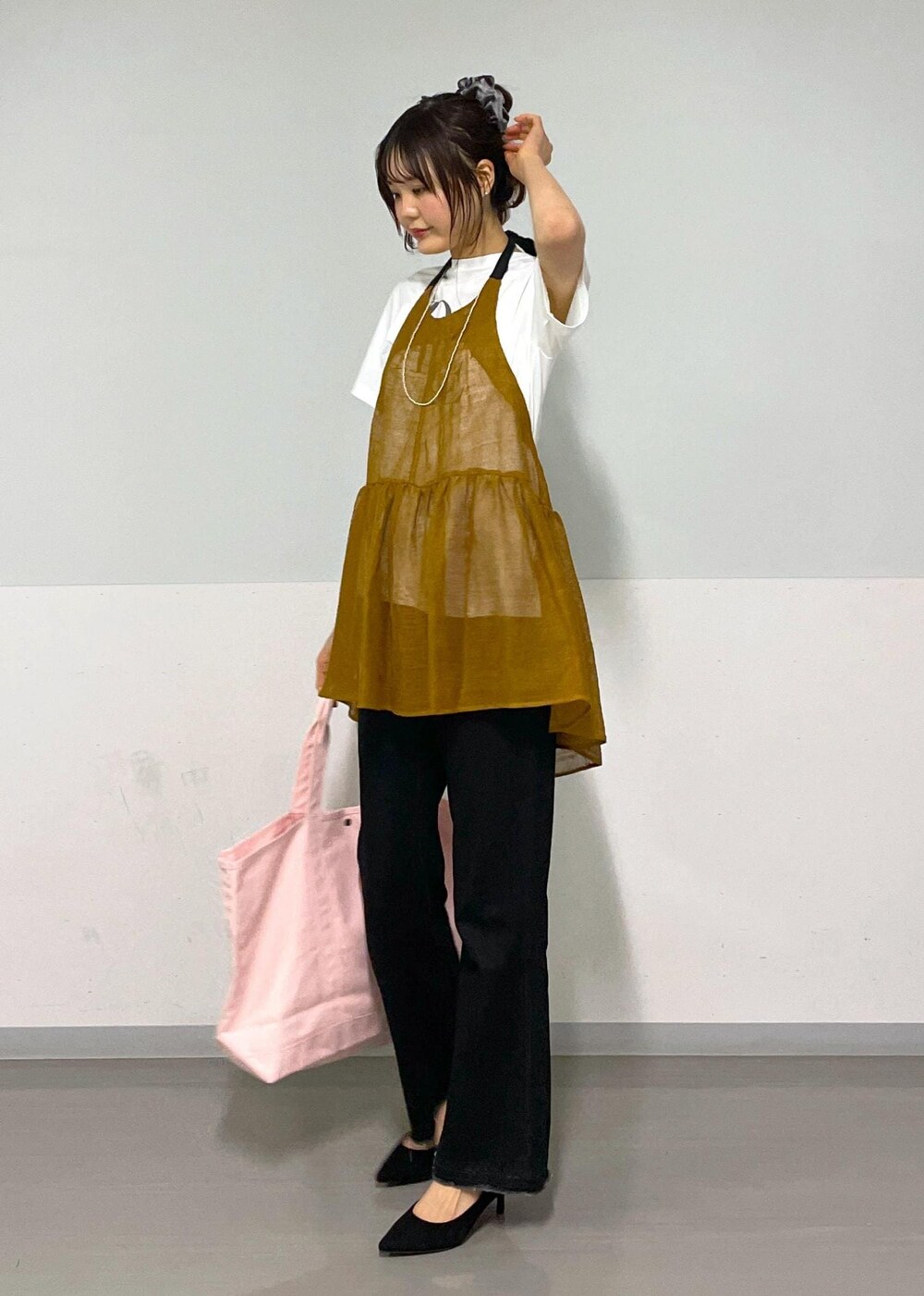 グレー系のデニムパンツ、ホワイト系のTシャツ/カットソー、ブラウン系のベストを着用したレディースの春コーディネートの7枚目の写真