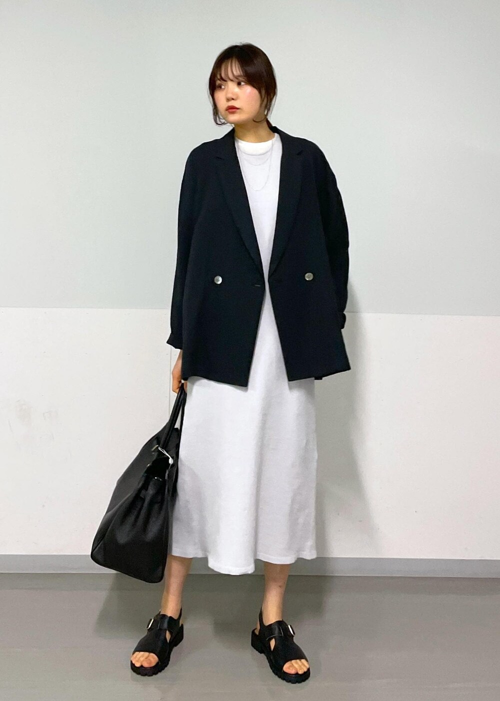 ブラック系のサンダル、グレー系のワンピース、ホワイト系のTシャツ/カットソーを着用したレディースの冬コーディネートの5枚目の写真