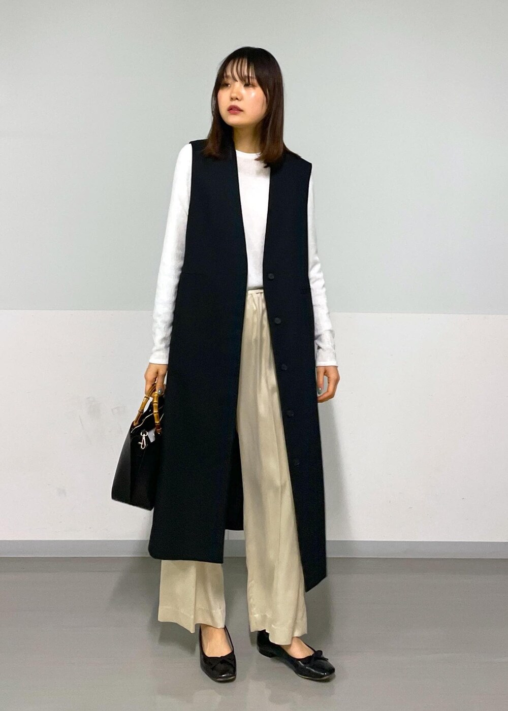 ベージュ系のその他パンツ、ブラック系のジャンパースカート、ホワイト系のTシャツ/カットソーを着用したレディースの冬コーディネートの6枚目の写真