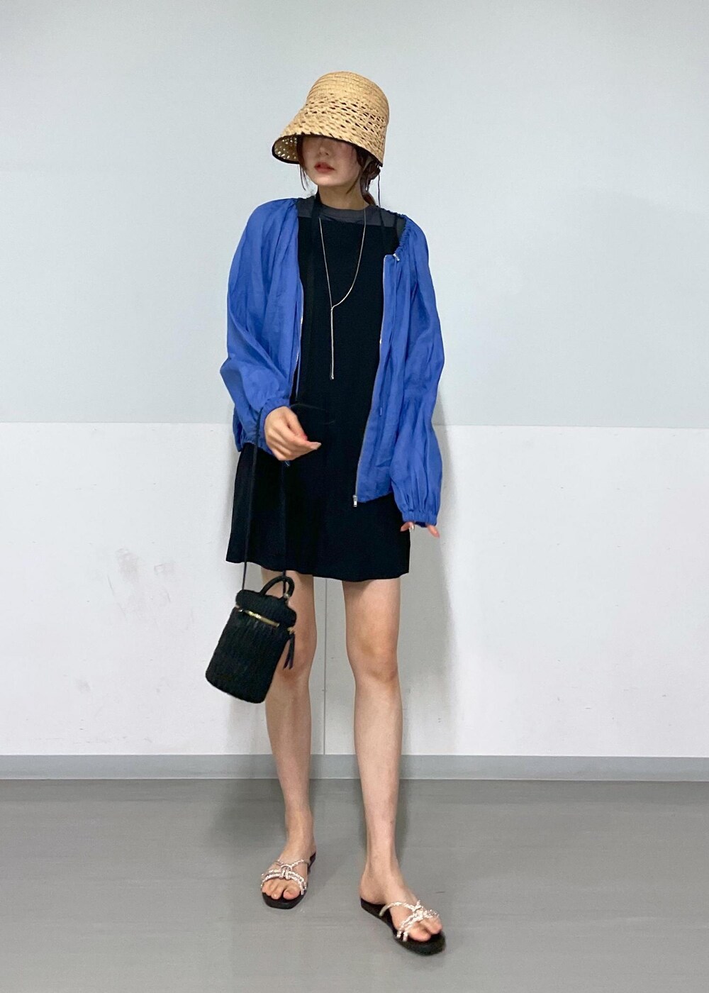 ブラック系のショルダーバッグ、ゴールド系のサンダル、ブラック系のTシャツ/カットソーを着用したレディースの夏コーディネートの2枚目の写真