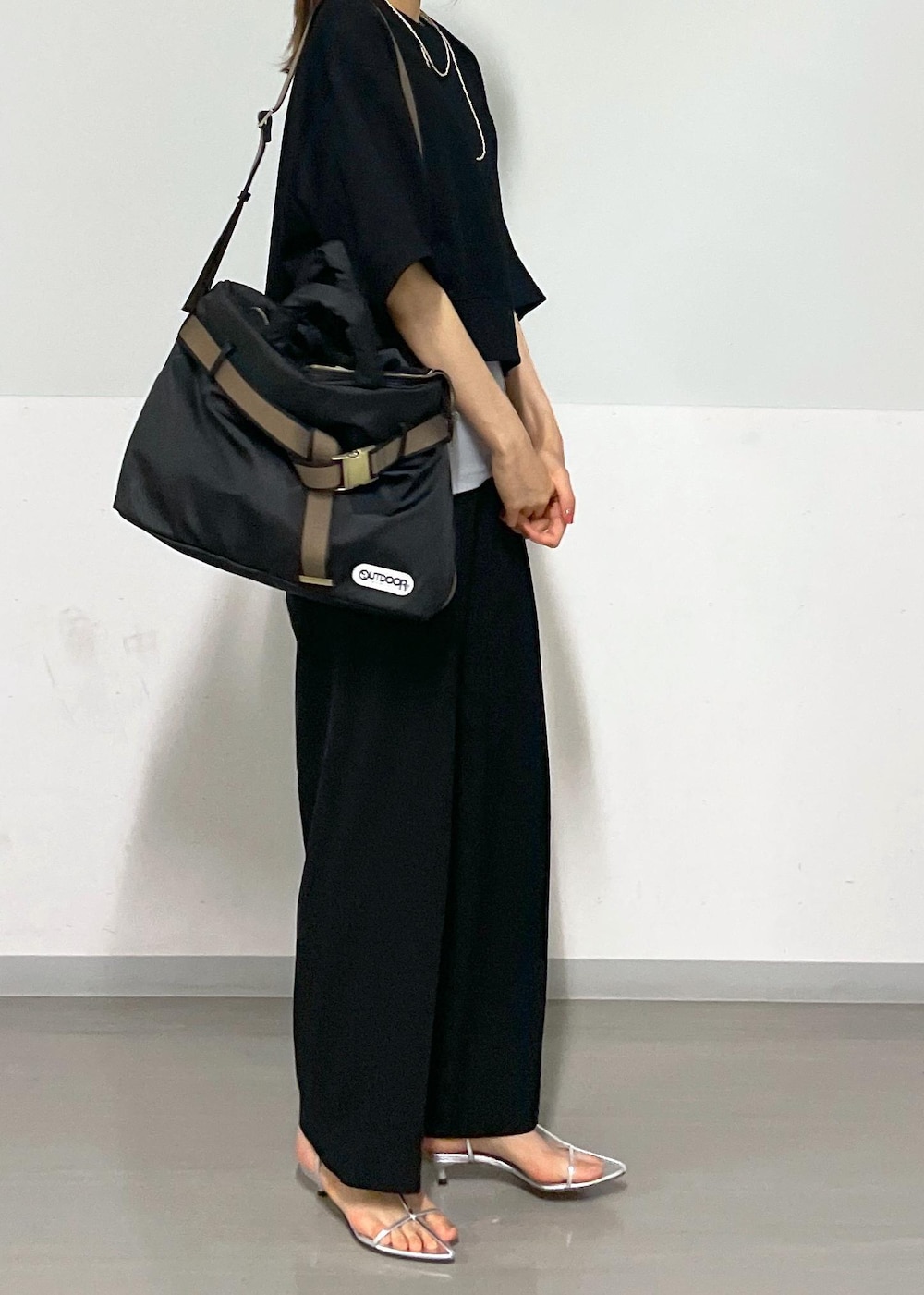 ブラック系のスラックス、シルバー系のサンダル、ブラック系のトートバッグを着用したレディースの夏コーディネートの8枚目の写真