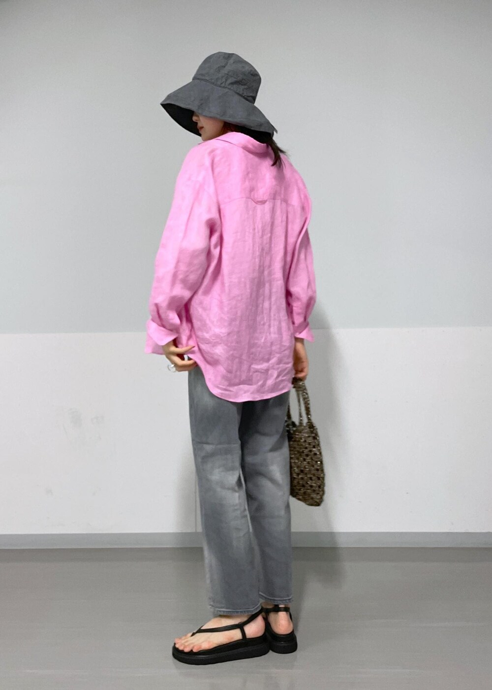 ブラック系のデニムパンツ、ブラック系のサンダル、ブラック系のハンドバッグを着用したレディースの春コーディネートの5枚目の写真