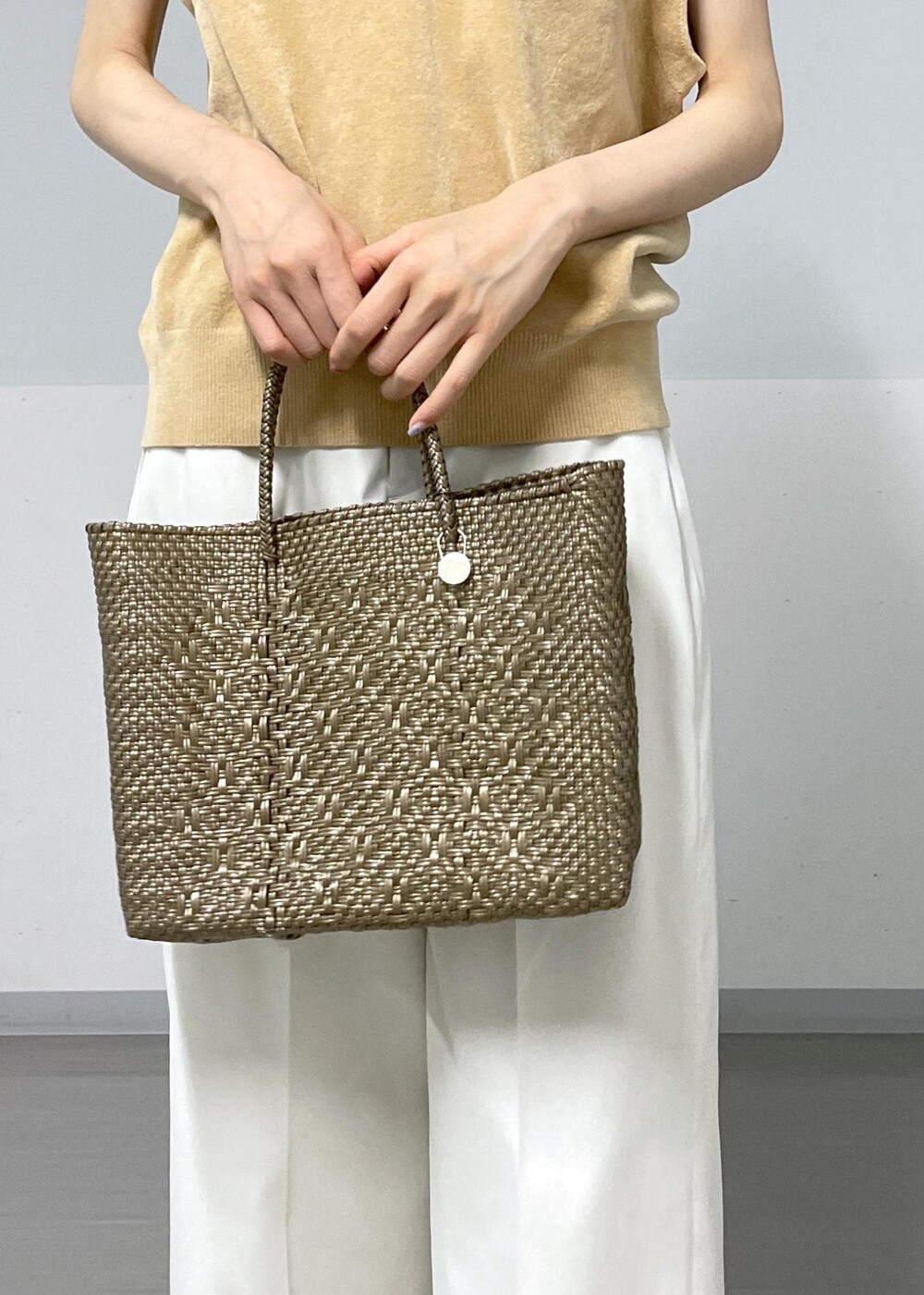 グレー系のタンクトップ、ホワイト系のその他パンツ、ホワイト系のサンダルを着用したレディースの夏コーディネートの7枚目の写真