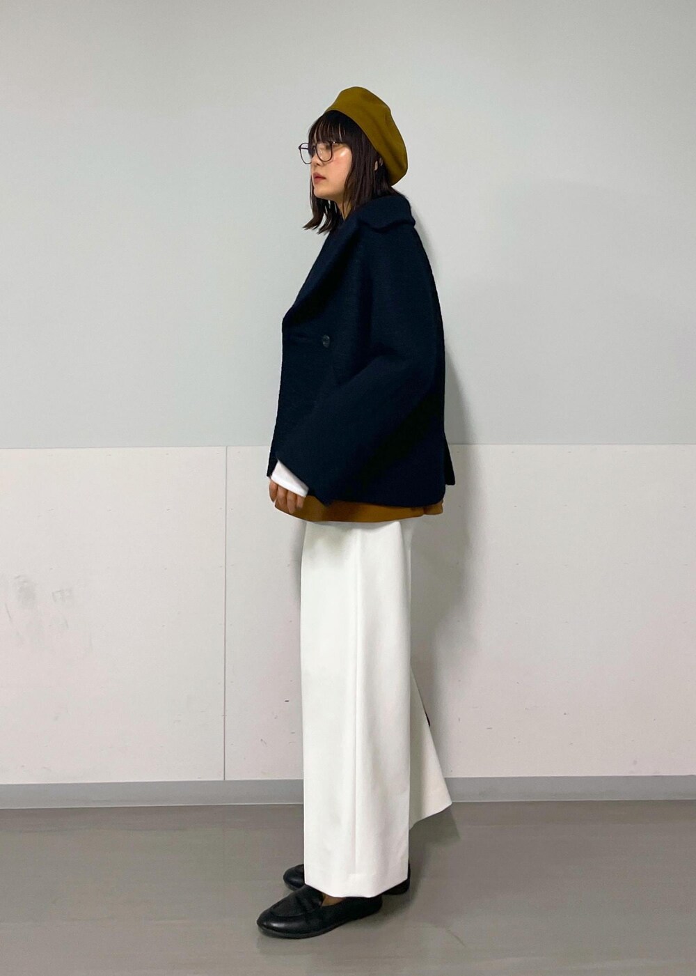 ブルー系のピーコート、ブラウン系のTシャツ/カットソー、ホワイト系のその他パンツを着用したレディースの秋コーディネートの9枚目の写真