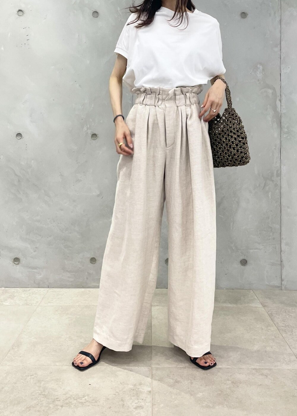 ブラック系のサンダル、ホワイト系のスラックス、ホワイト系のテーラードジャケットを着用したレディースの春コーディネートの6枚目の写真