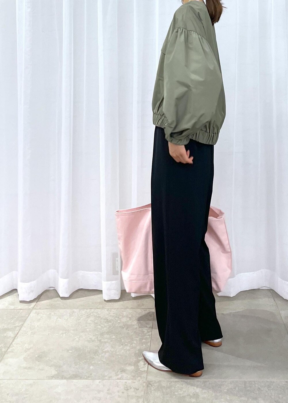 ブラック系のスラックス、グリーン系のブルゾン、シルバー系のパンプスを着用したレディースの冬コーディネートの6枚目の写真