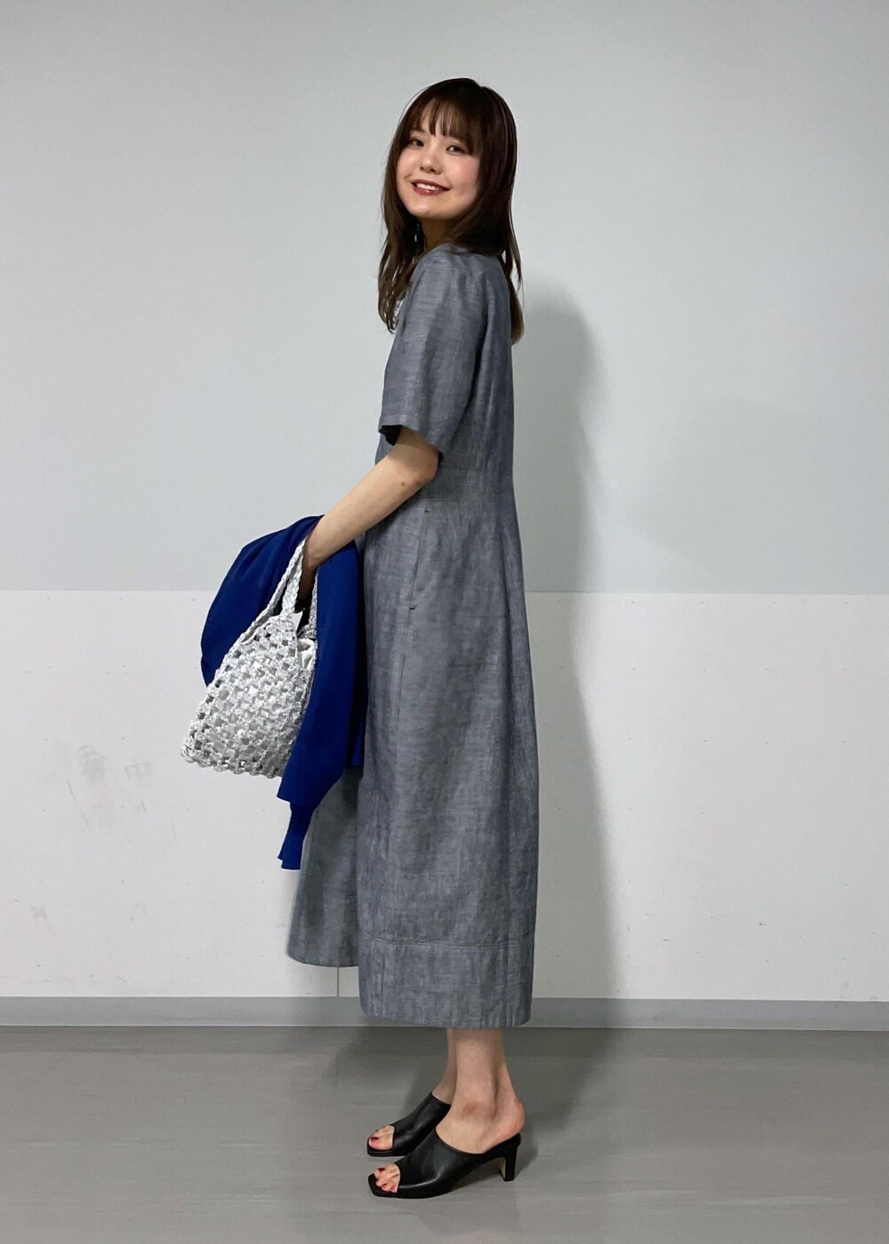 ブラック系のサンダル、ホワイト系のハンドバッグ、ブルー系のカーディガン/ボレロを着用したレディースの夏コーディネートの8枚目の写真