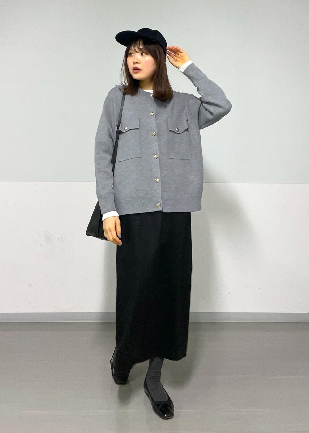 グレー系のカーディガン/ボレロ、ホワイト系のTシャツ/カットソー、ブラック系のハンドバッグを着用したレディースの冬コーディネートの10枚目の写真