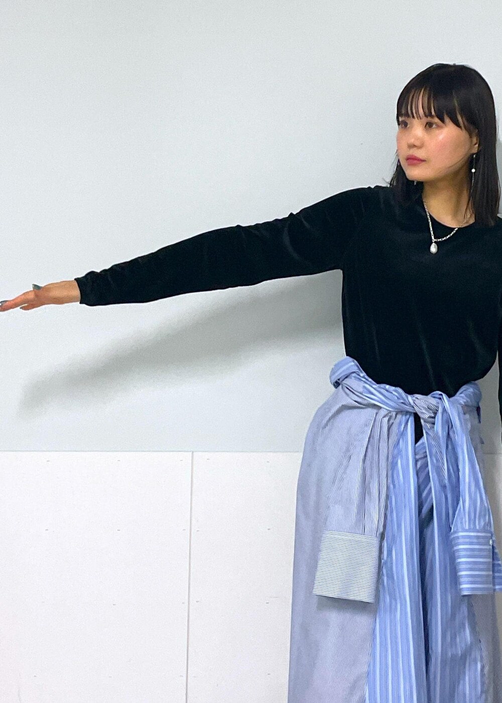 ブラック系のショルダーバッグ、ブルー系のシャツワンピース、ホワイト系のネックレスを着用したレディースの秋コーディネートの3枚目の写真