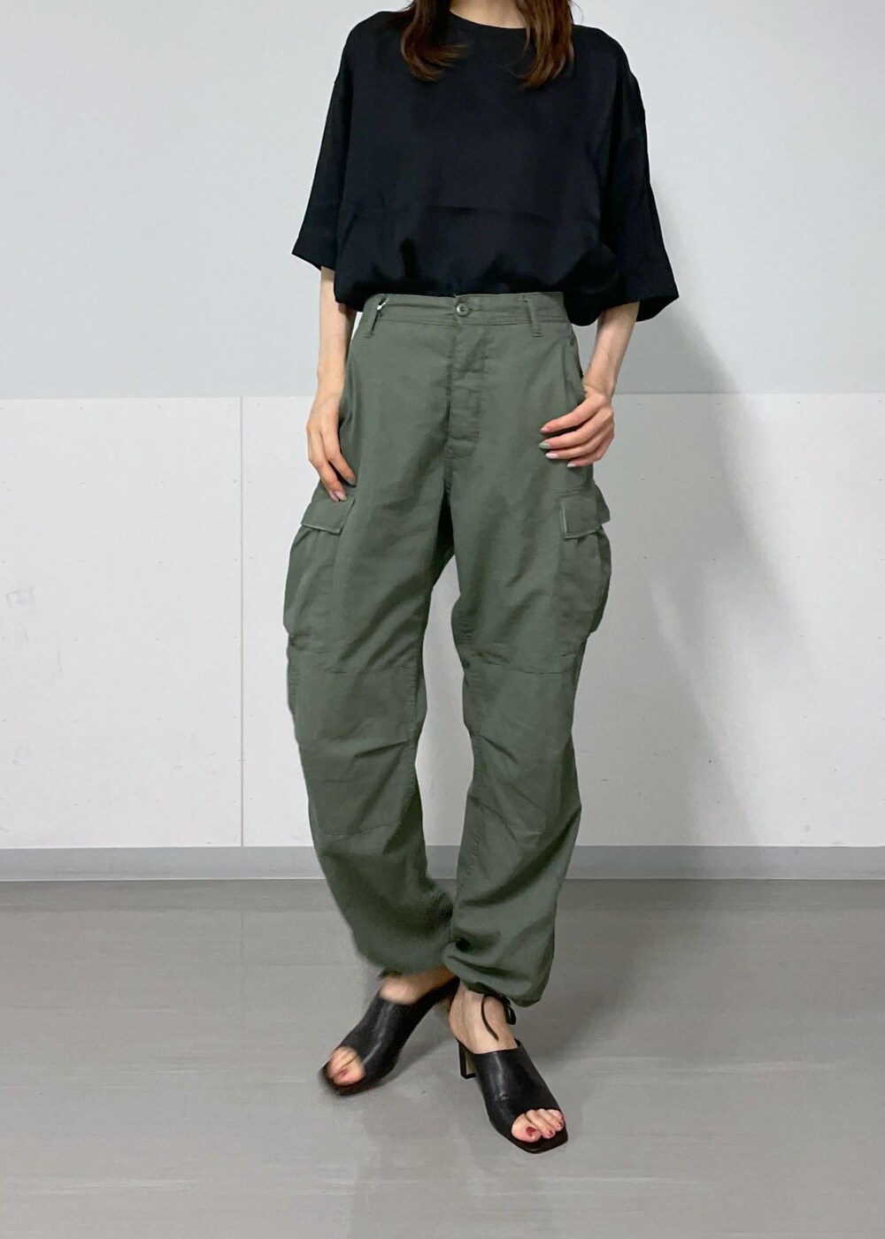 ホワイト系のトートバッグ、ブラック系のサンダル、グリーン系のカーゴパンツを着用したレディースの夏コーディネートの5枚目の写真