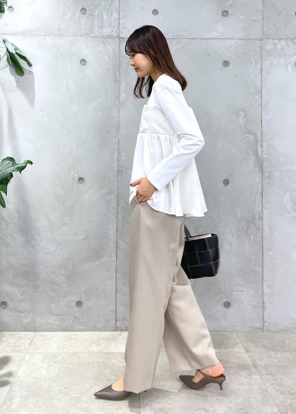 ベージュ系のその他パンツ、ブラック系のトートバッグ、ホワイト系のTシャツ/カットソーを着用したレディースの冬コーディネートの3枚目の写真