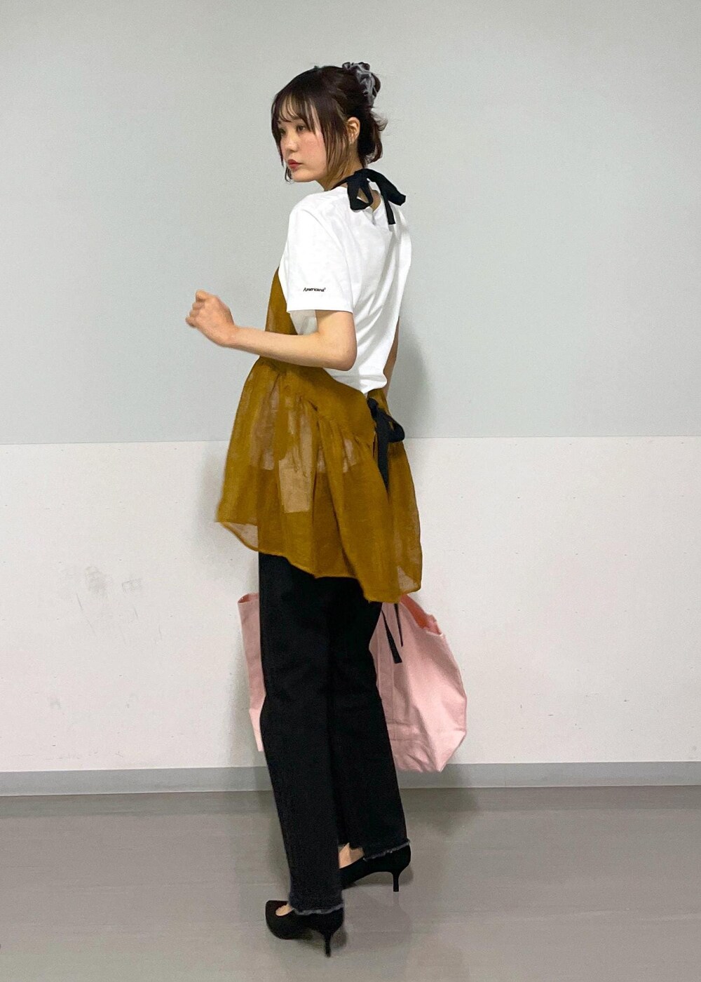 グレー系のデニムパンツ、ホワイト系のTシャツ/カットソー、ブラウン系のベストを着用したレディースの春コーディネートの2枚目の写真