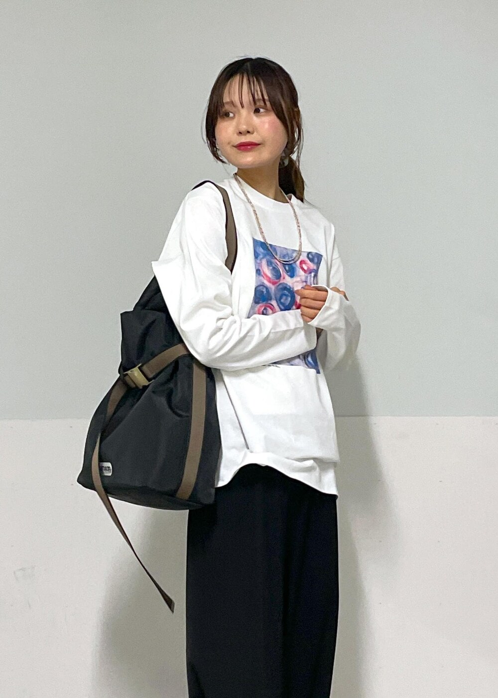 ホワイト系のカーディガン/ボレロ、ブラック系のスラックス、ブラック系のトートバッグを着用したレディースの夏コーディネートの7枚目の写真