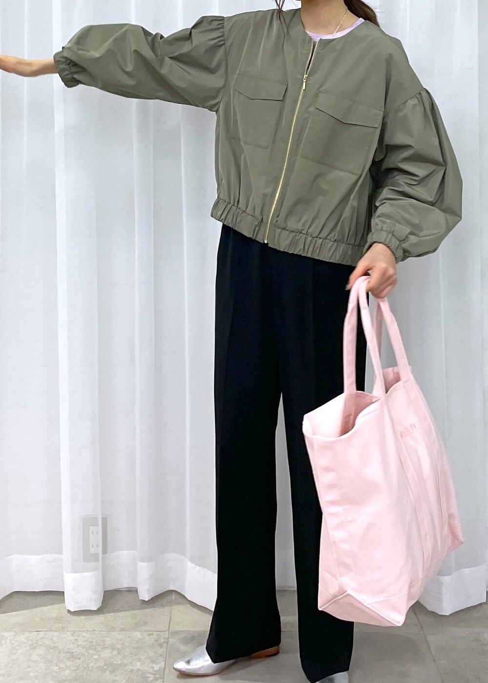 ブラック系のスラックス、グリーン系のブルゾン、シルバー系のパンプスを着用したレディースの冬コーディネートの9枚目の写真