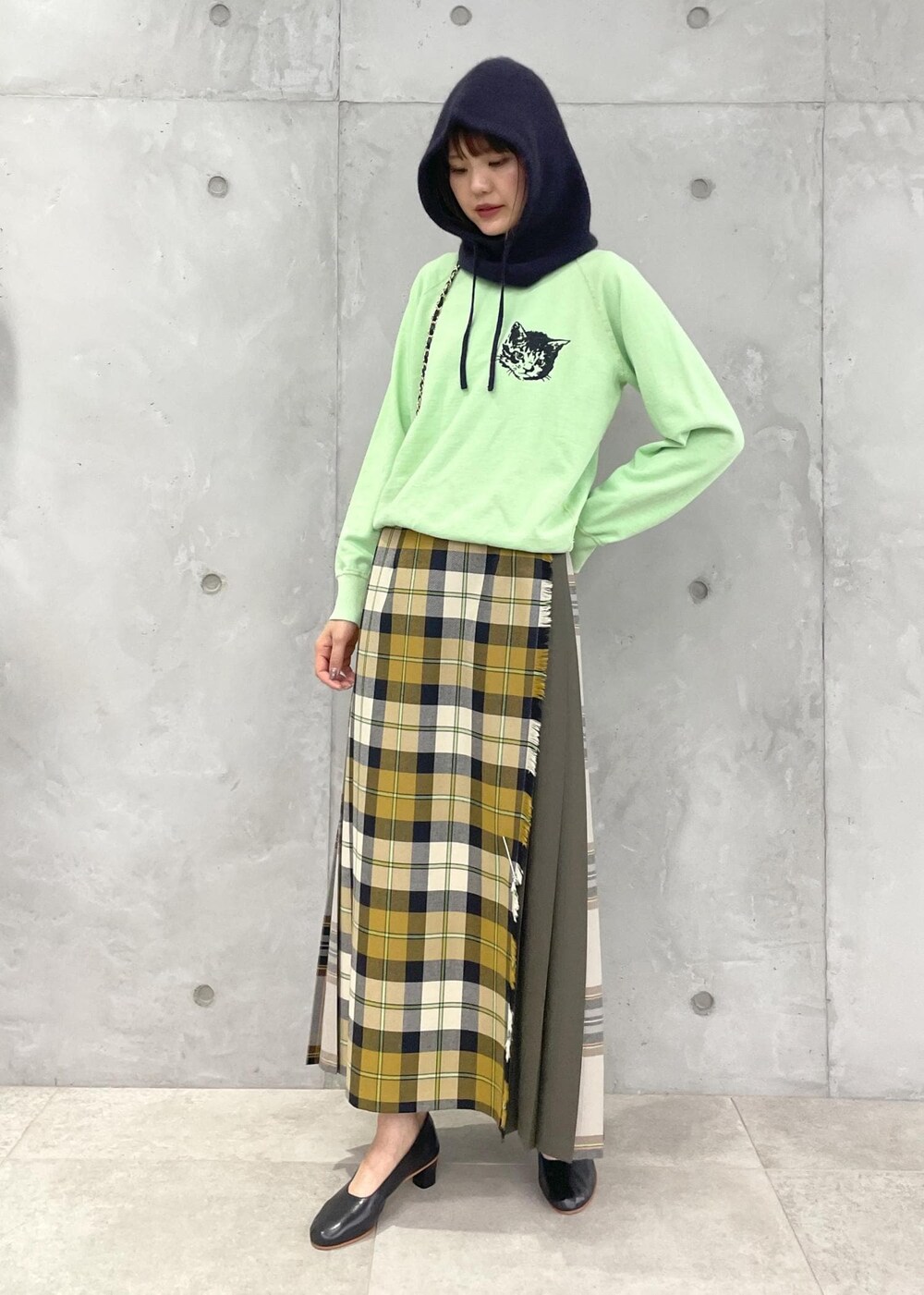 イエロー系のスカート、グリーン系のスウェット、ブラック系のショルダーバッグを着用したレディースの夏コーディネートの9枚目の写真