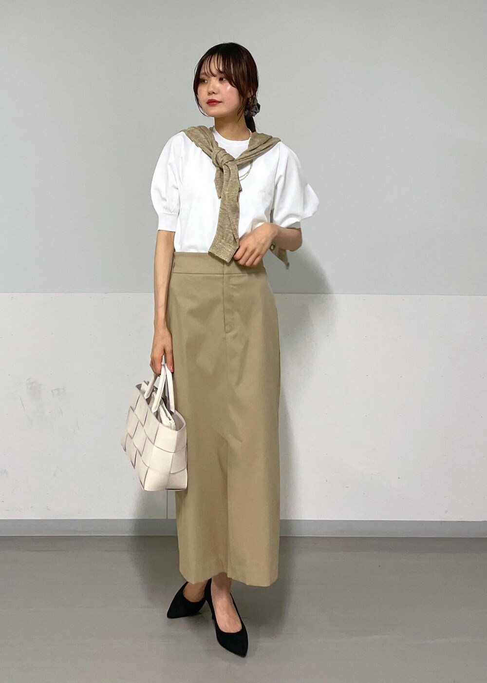 ホワイト系のトートバッグ、ベージュ系のスカート、ベージュ系のカーディガン/ボレロを着用したレディースの夏コーディネートの7枚目の写真