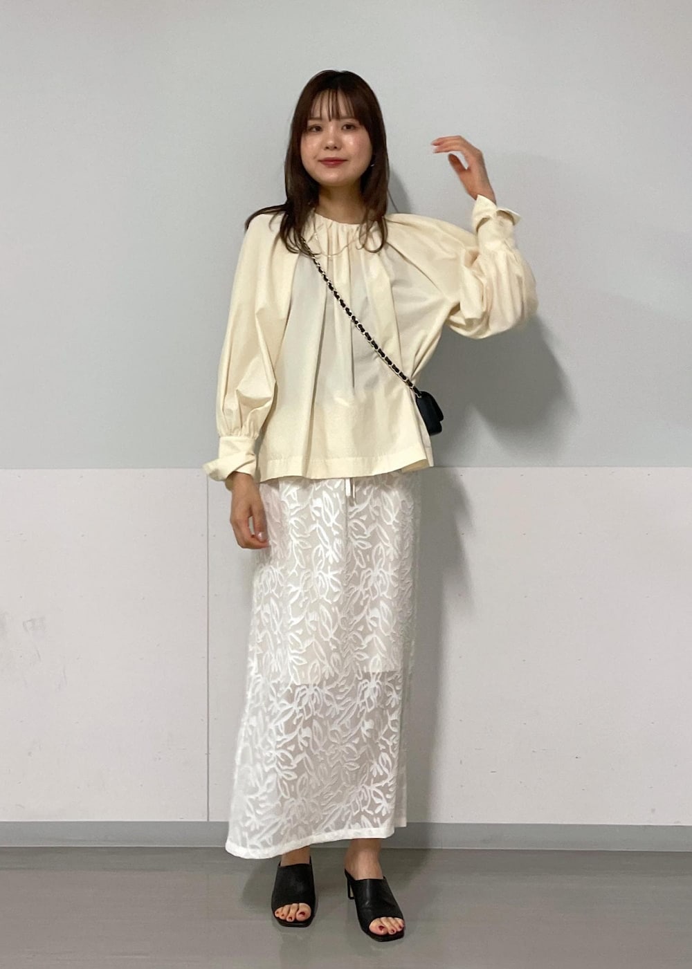 ブラック系のショルダーバッグ、ブラック系のサンダル、グリーン系のタンクトップを着用したレディースの夏コーディネートの2枚目の写真