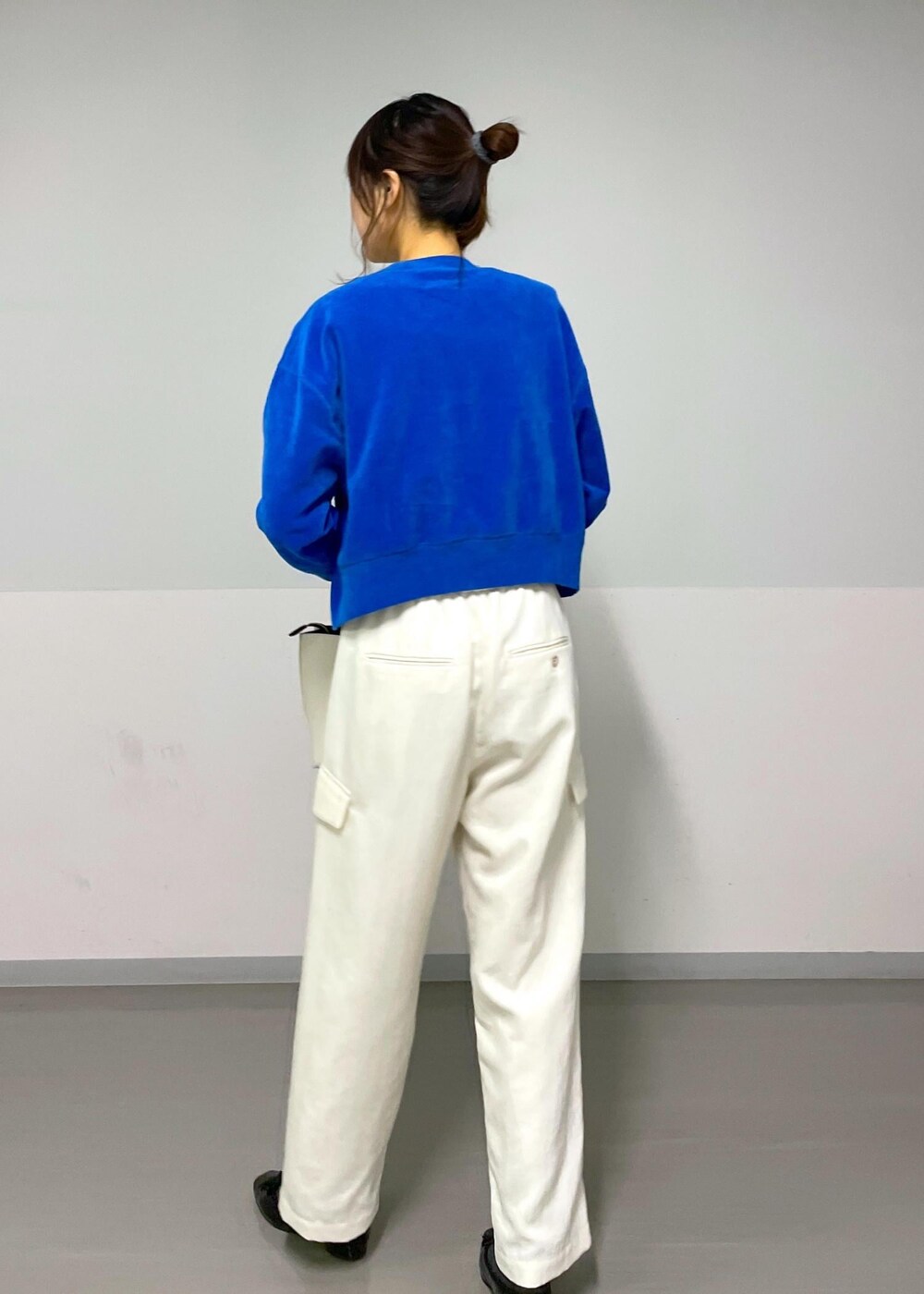 ブルー系のニット/セーター、ホワイト系のカーゴパンツ、ホワイト系のTシャツ/カットソーを着用したレディースの冬コーディネートの3枚目の写真