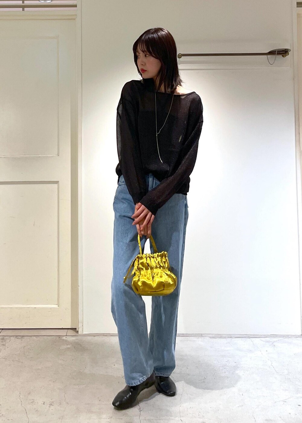 イエロー系のショルダーバッグ、ブルー系のデニムパンツ、ブラック系のTシャツ/カットソーを着用したレディースの夏コーディネートの6枚目の写真