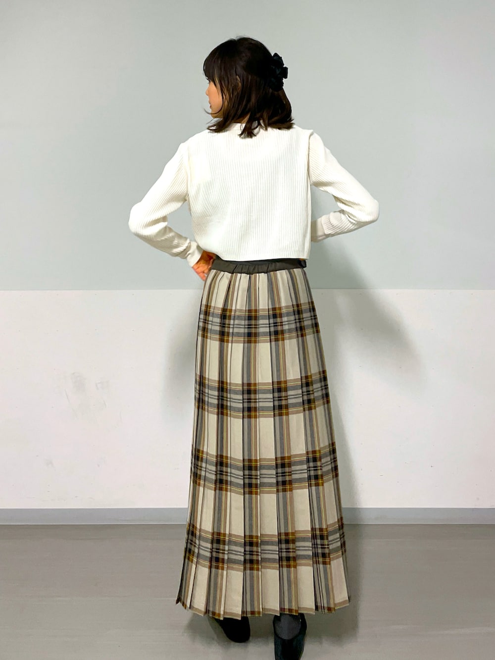 ホワイト系のカーディガン/ボレロ、イエロー系のスカート、ブラック系のシューズを着用したレディースの冬コーディネートの3枚目の写真