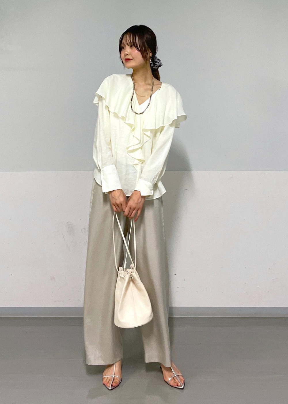 ホワイト系のシャツ/ブラウス、シルバー系のサンダル、ホワイト系のショルダーバッグを着用したレディースの夏コーディネートの9枚目の写真