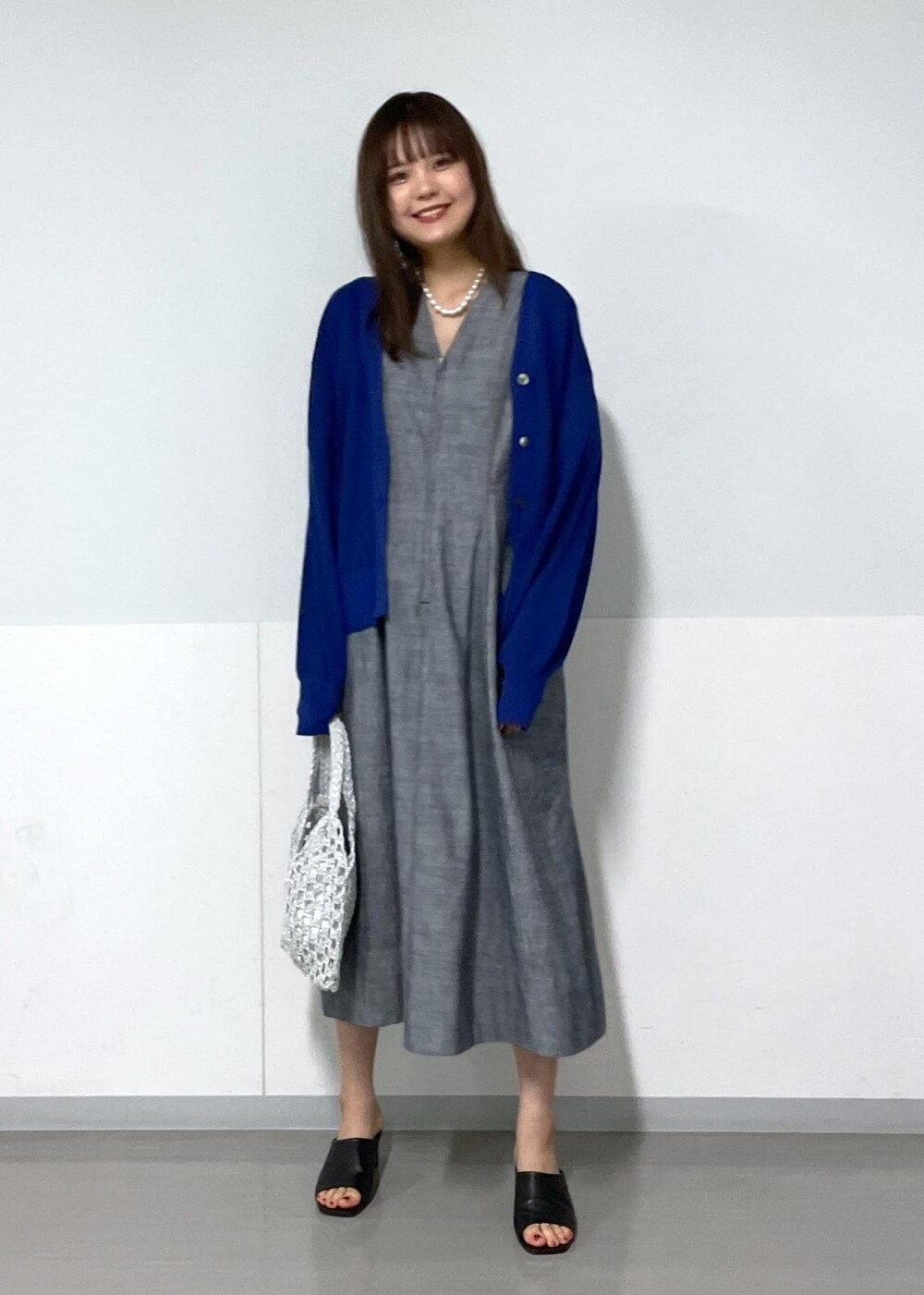 ブラック系のサンダル、ホワイト系のハンドバッグ、ブルー系のカーディガン/ボレロを着用したレディースの夏コーディネートの7枚目の写真