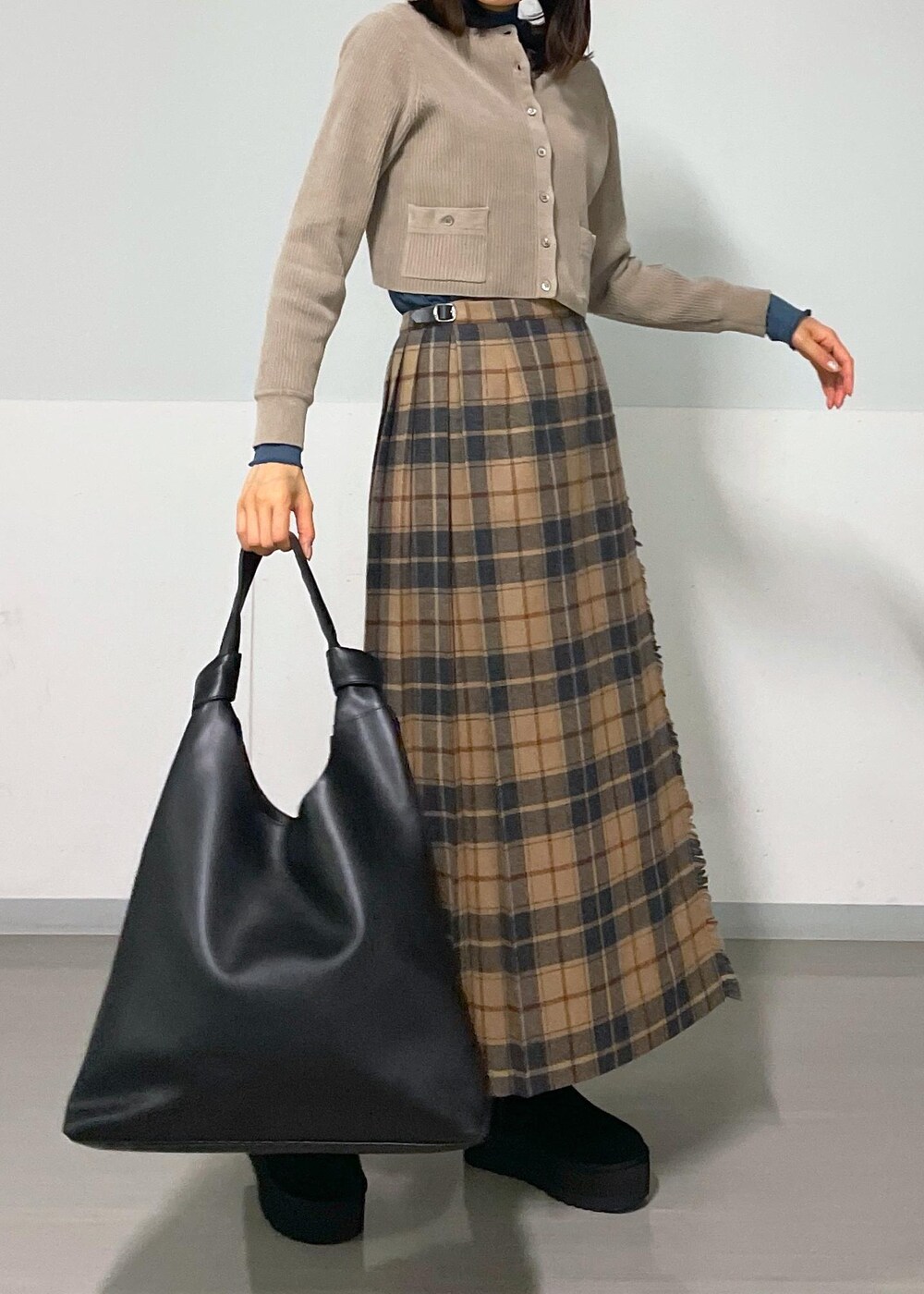 ブルー系のTシャツ/カットソー、ベージュ系のスカート、グレー系のカーディガン/ボレロを着用したレディースの秋コーディネートの10枚目の写真