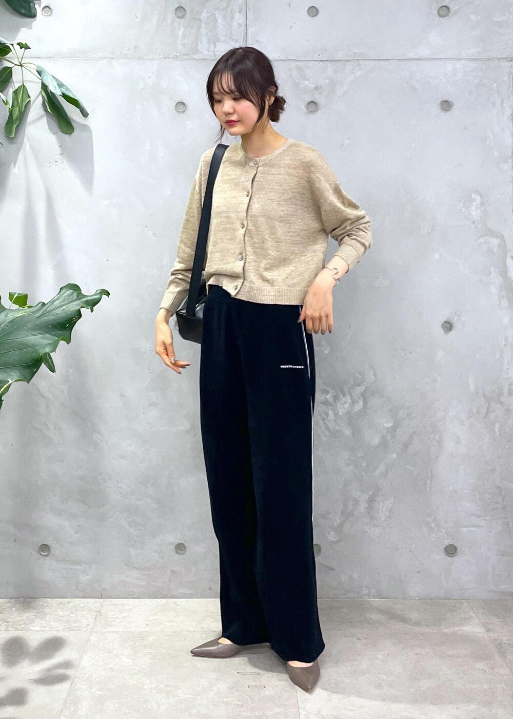 ブラック系のショルダーバッグ、ブラック系のその他パンツ、ベージュ系のカーディガン/ボレロを着用したレディースの冬コーディネートの7枚目の写真