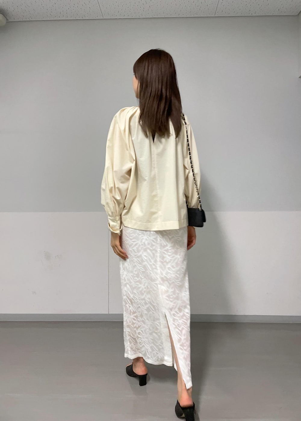 ブラック系のショルダーバッグ、ブラック系のサンダル、グリーン系のタンクトップを着用したレディースの夏コーディネートの3枚目の写真