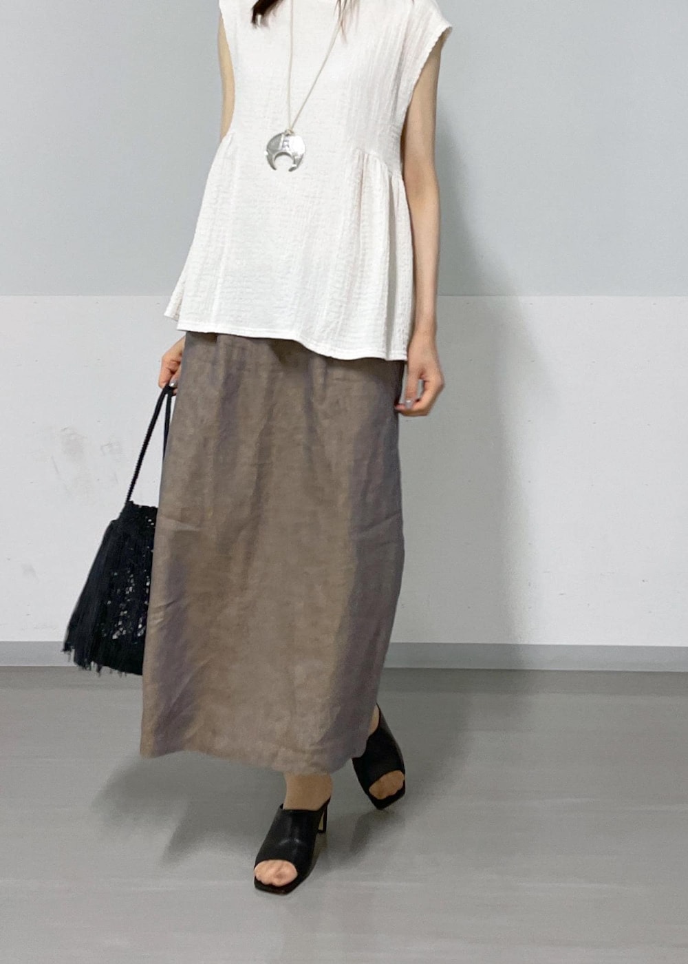 ホワイト系のTシャツ/カットソー、ブラック系のサンダル、ブラック系のトートバッグを着用したレディースの夏コーディネートの5枚目の写真