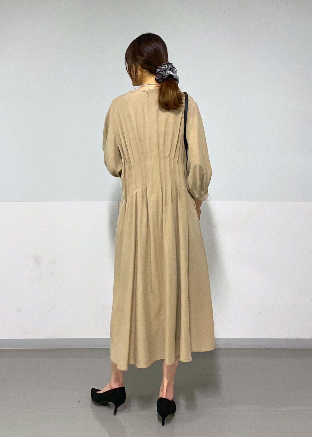 ブラック系のショルダーバッグ、ベージュ系のワンピース、ホワイト系のカーディガン/ボレロを着用したレディースの春コーディネートの9枚目の写真