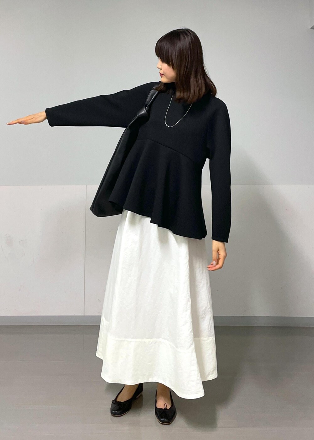 ブラック系のバレエシューズ、ホワイト系のスカート、ブラック系のTシャツ/カットソーを着用したレディースの秋コーディネートの3枚目の写真