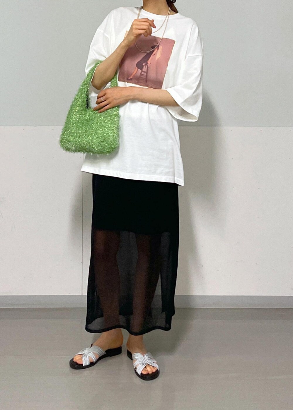 ブラック系のスカート、グリーン系のハンドバッグ、ホワイト系のTシャツ/カットソーを着用したレディースの夏コーディネートの9枚目の写真