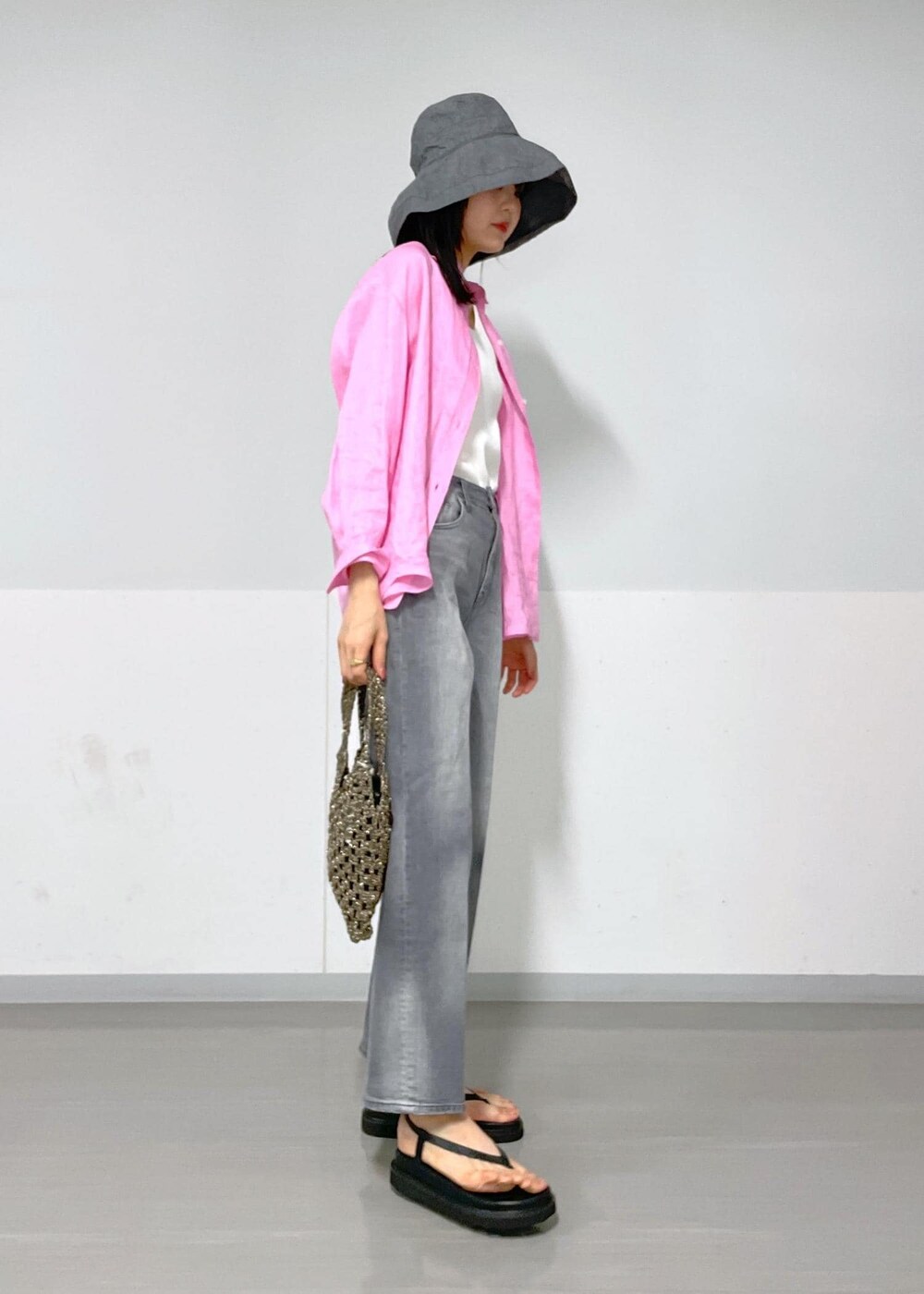 ブラック系のデニムパンツ、ブラック系のサンダル、ブラック系のハンドバッグを着用したレディースの春コーディネートの7枚目の写真