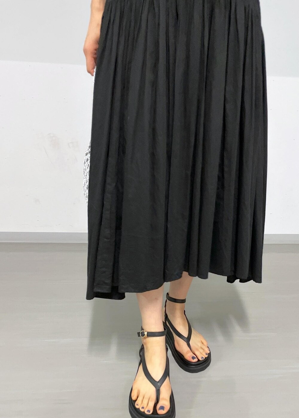 ブラック系のサンダル、ブラック系のスカート、グレー系のTシャツ/カットソーを着用したレディースの春コーディネートの5枚目の写真