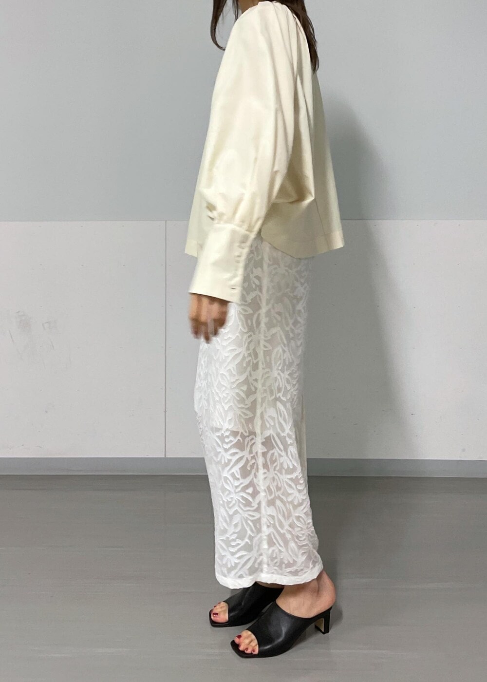 ブラック系のショルダーバッグ、ブラック系のサンダル、グリーン系のタンクトップを着用したレディースの夏コーディネートの7枚目の写真