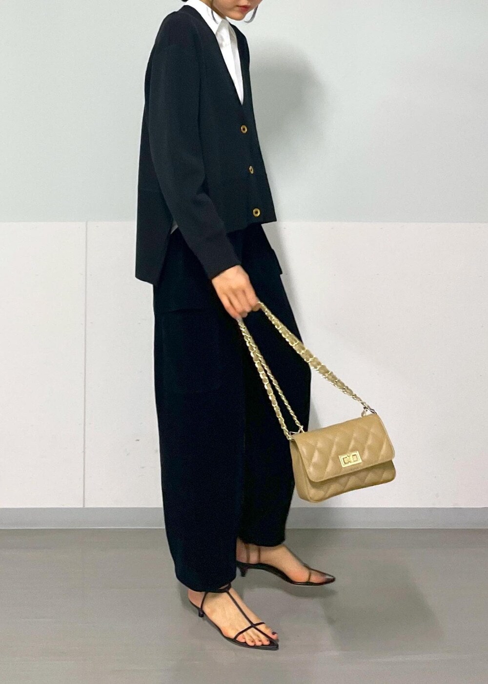 ベージュ系のショルダーバッグ、ブラック系のサンダル、ブラック系のカーゴパンツを着用したレディースの秋コーディネートの4枚目の写真