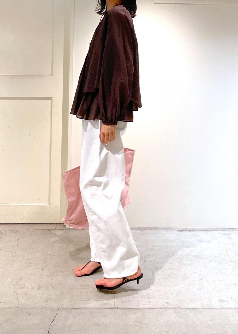 グレー系のタンクトップ、ブラック系のサンダル、ホワイト系のデニムパンツを着用したレディースの夏コーディネートの5枚目の写真