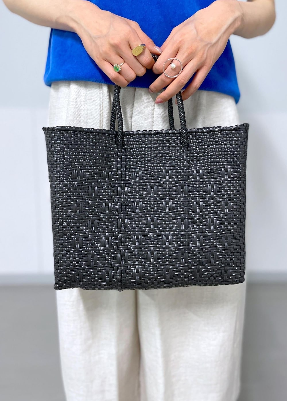 ブラック系のかごバッグ、ホワイト系のスラックス、ホワイト系のテーラードジャケットを着用したレディースの春コーディネートの5枚目の写真