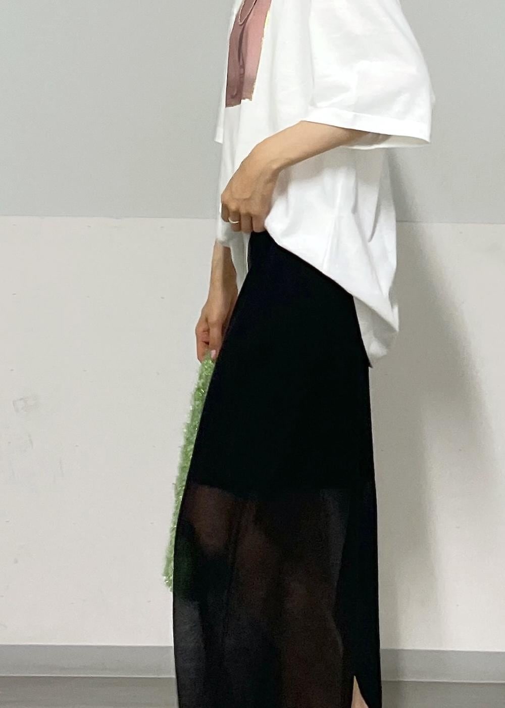 ブラック系のスカート、グリーン系のハンドバッグ、ホワイト系のTシャツ/カットソーを着用したレディースの夏コーディネートの4枚目の写真