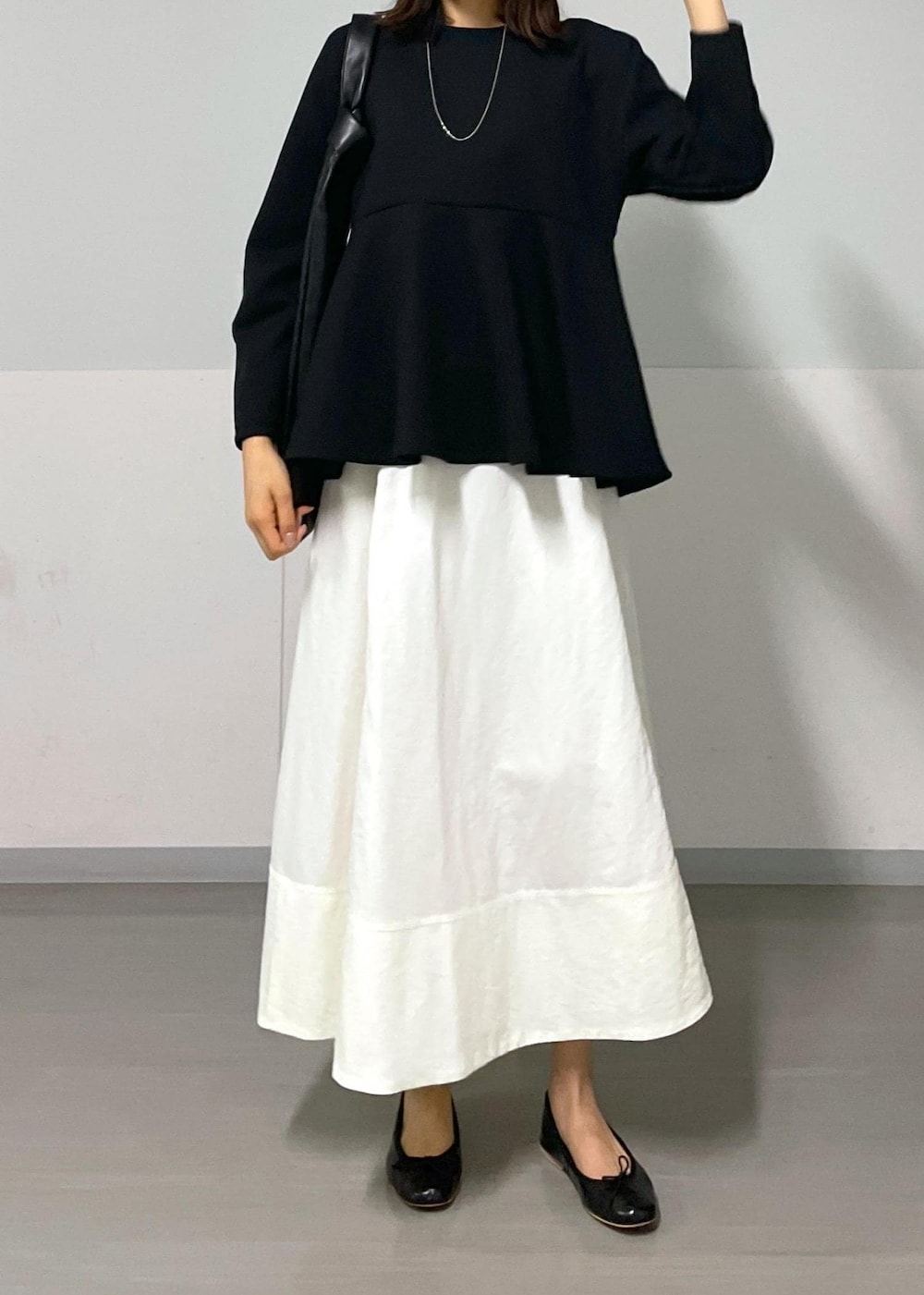 ブラック系のバレエシューズ、ホワイト系のスカート、ブラック系のTシャツ/カットソーを着用したレディースの秋コーディネートの4枚目の写真