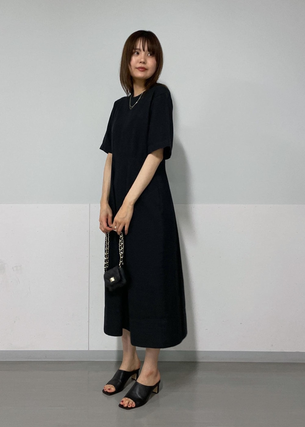 ブラック系のサンダル、ホワイト系のカーディガン/ボレロ、ブラック系のワンピースを着用したレディースの夏コーディネートの3枚目の写真