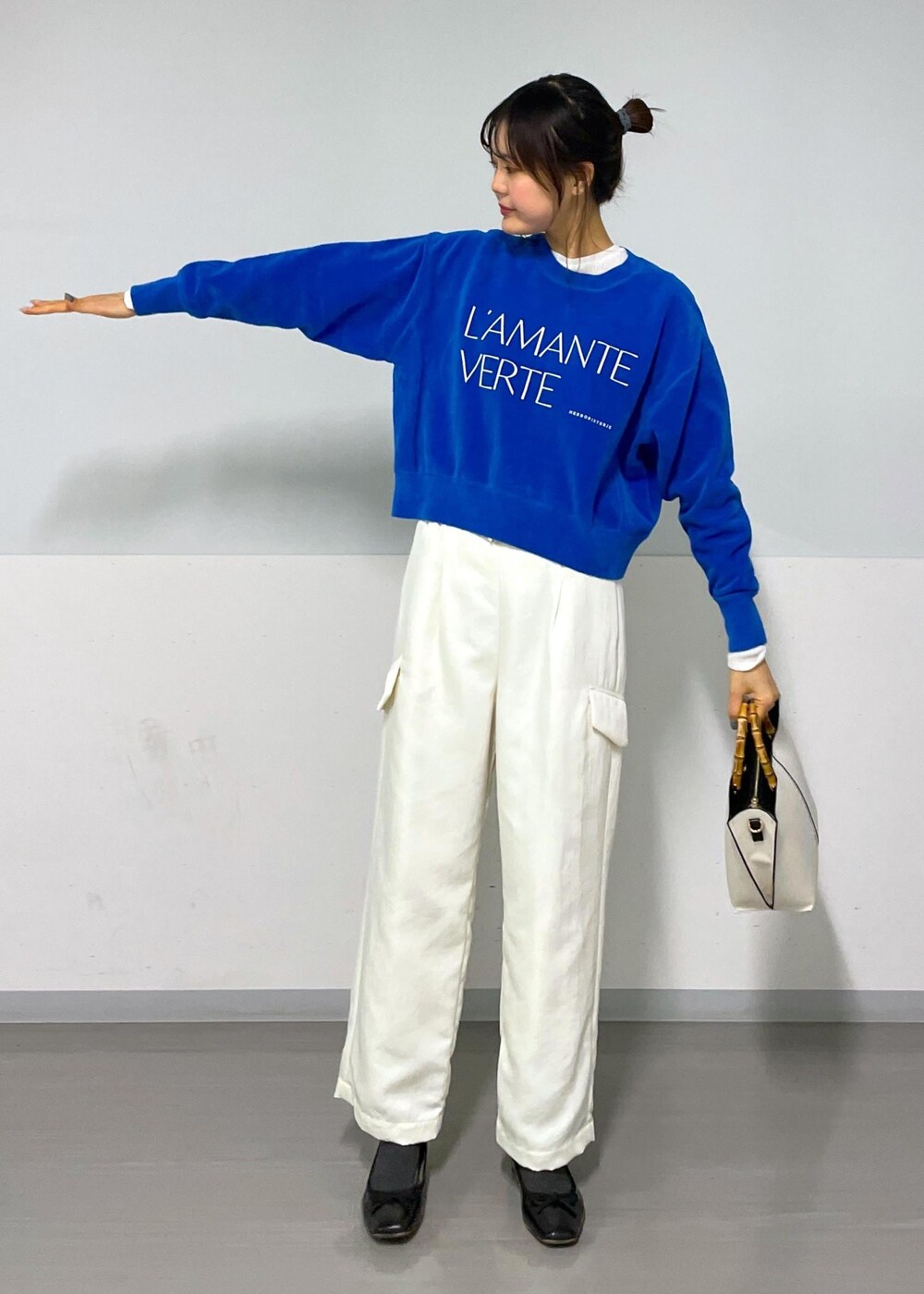 ブルー系のニット/セーター、ホワイト系のカーゴパンツ、ホワイト系のTシャツ/カットソーを着用したレディースの冬コーディネートの6枚目の写真