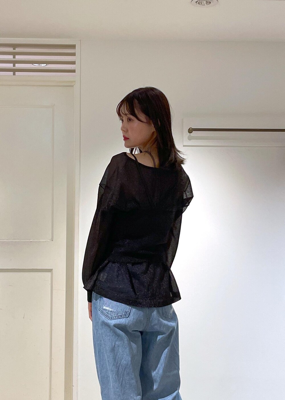 イエロー系のショルダーバッグ、ブルー系のデニムパンツ、ブラック系のTシャツ/カットソーを着用したレディースの夏コーディネートの2枚目の写真