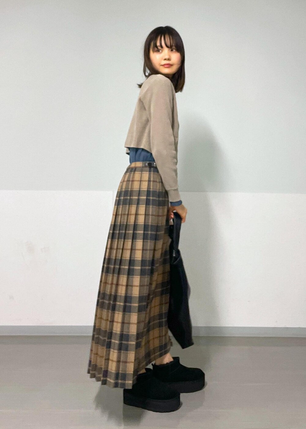 ブルー系のTシャツ/カットソー、ベージュ系のスカート、グレー系のカーディガン/ボレロを着用したレディースの秋コーディネートの3枚目の写真