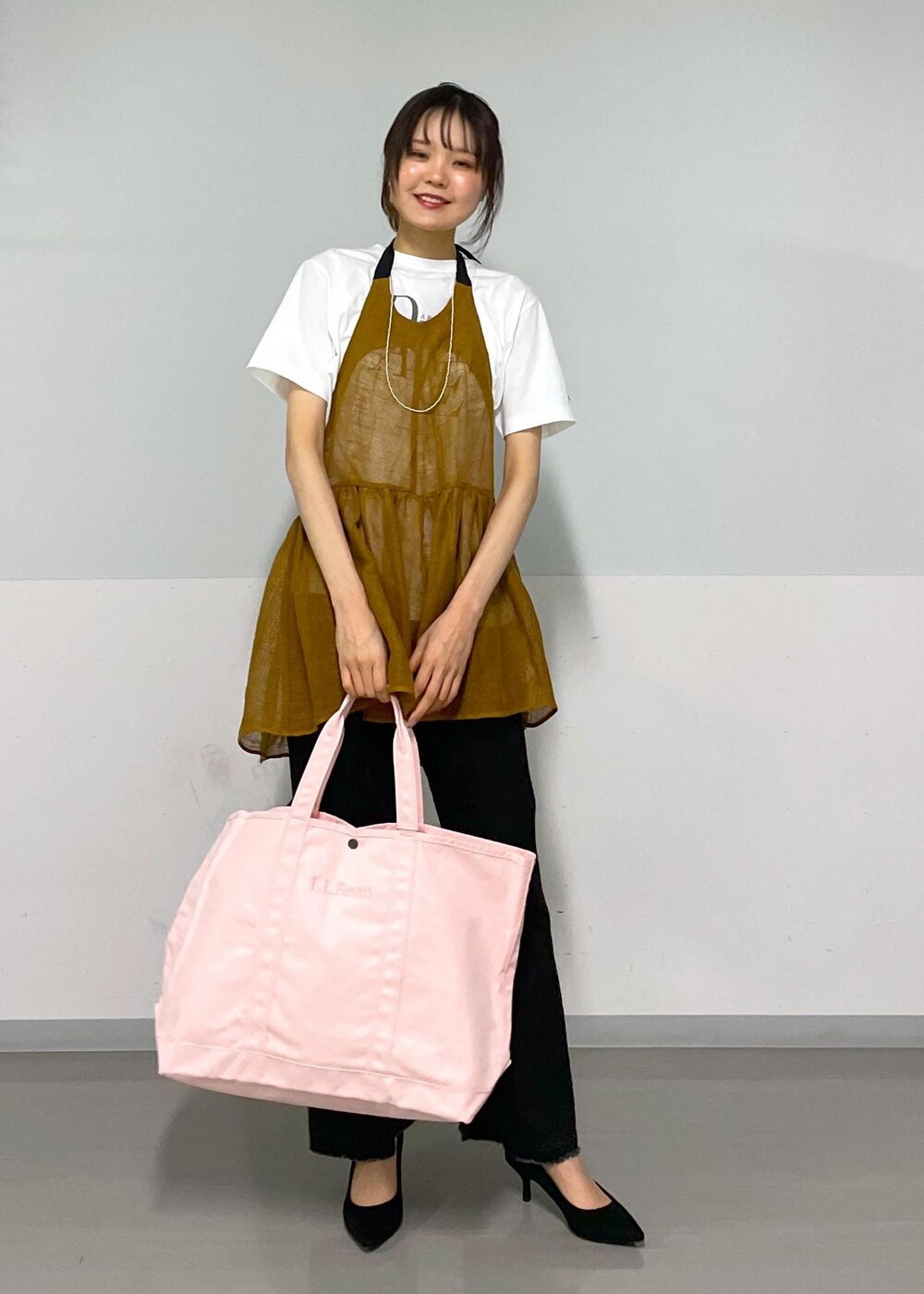 グレー系のデニムパンツ、ホワイト系のTシャツ/カットソー、ブラウン系のベストを着用したレディースの春コーディネートの4枚目の写真