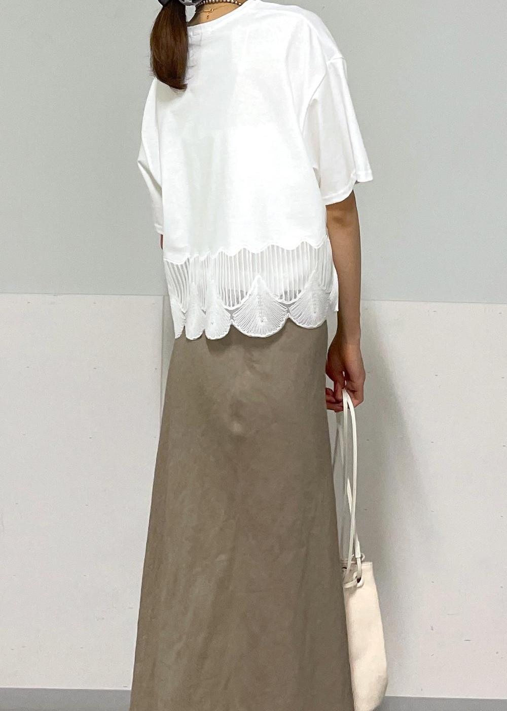 ホワイト系のキャミソール、シルバー系のサンダル、グリーン系のスカートを着用したレディースの夏コーディネートの5枚目の写真