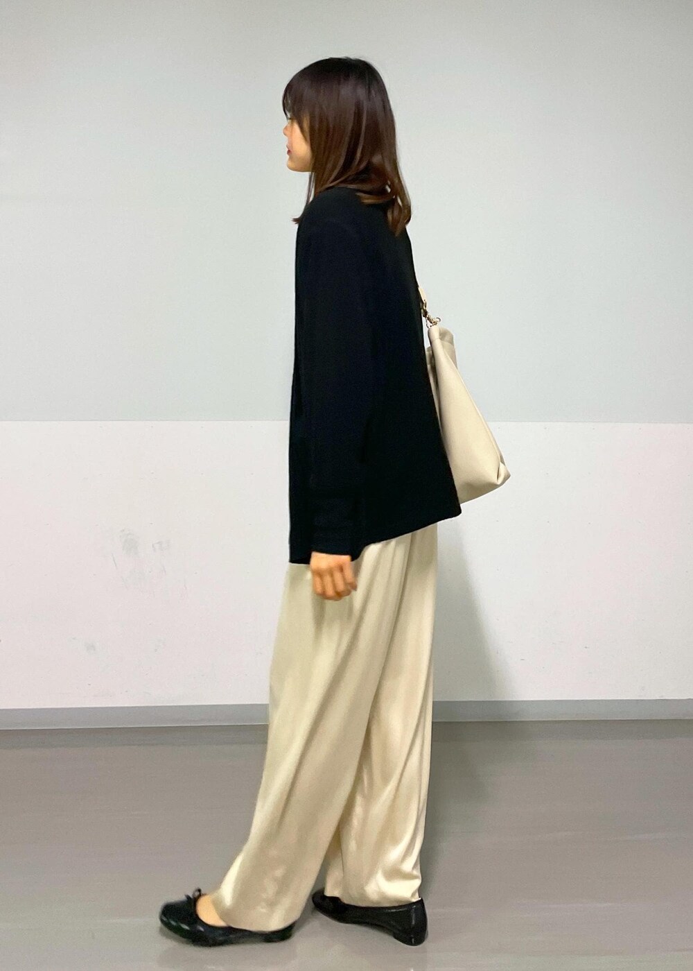 ベージュ系のその他パンツ、ブラック系のカーディガン/ボレロ、ベージュ系のトートバッグを着用したレディースの冬コーディネートの7枚目の写真