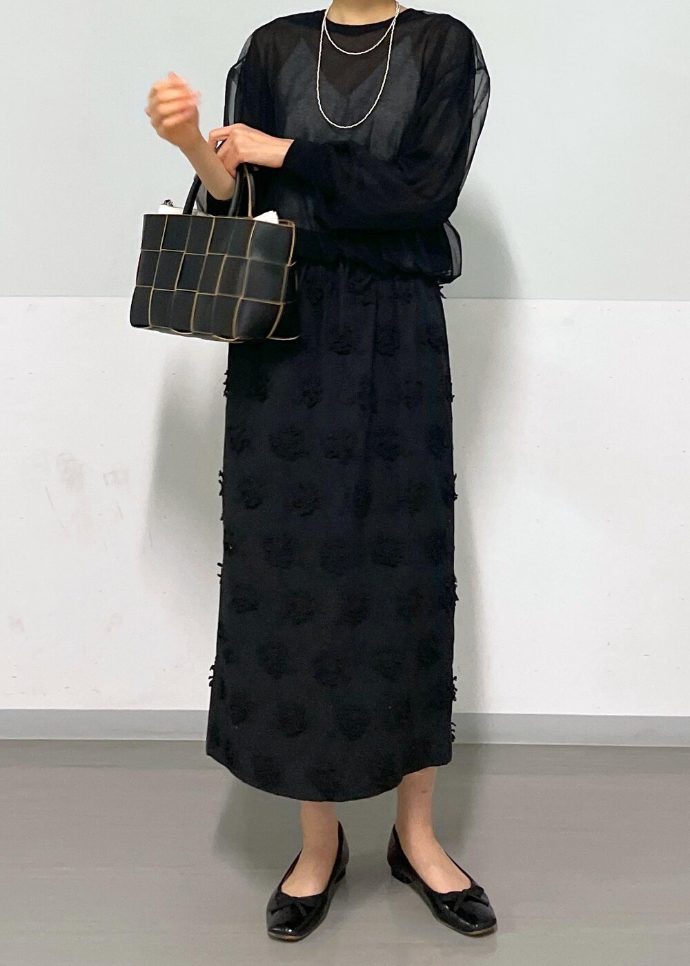 ブラック系のトートバッグ、ホワイト系のキャミソール、ブラック系のTシャツ/カットソーを着用したレディースの春コーディネートの5枚目の写真