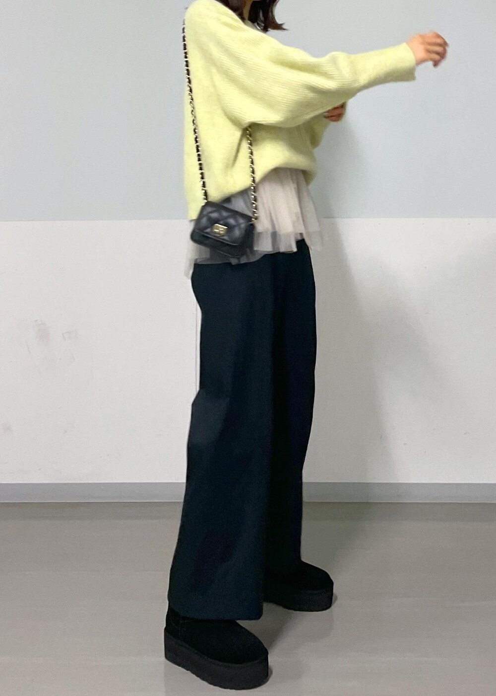 ブラック系のショルダーバッグ、ブラック系のその他パンツ、イエロー系のニット/セーターを着用したレディースの秋コーディネートの9枚目の写真